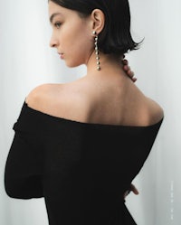 the back of a woman wearing a black off the shoulder top